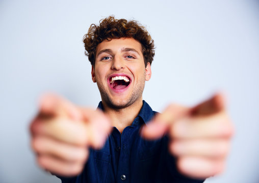 Portrait of a laughing man pointing at you