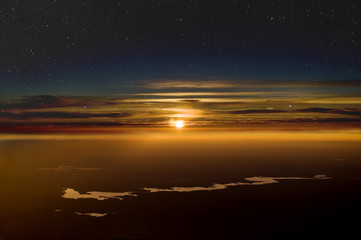 High altitude sunset. Stars above clouds below.