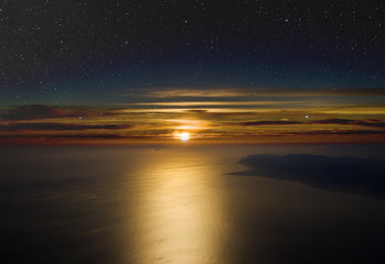 High altitude sunset. Stars above, cloudsand sea below.