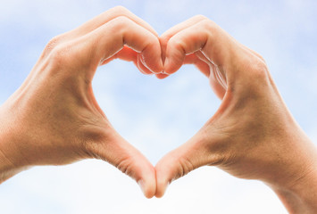 hands forming a heart shape with sky and cloud