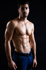 Fototapeta na wymiar Beautiful and muscular man in dark background.
