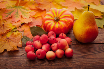 Autumn leaves on wooden table. Fruits and vegetables.