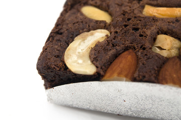 A piece of brownie and cashew isolated on white