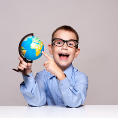 Portrait of a little boy holding a globe. Travel concept