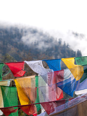 Colorful prayer flags over the misty himalayas in Bhutan