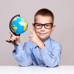 Portrait of a little boy holding a globe. Travel concept