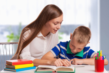 Fototapeta premium Mother Helping Son With Homework At Table