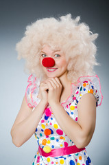 Clown with white wig against grey background
