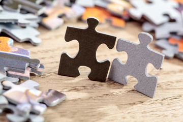 Black and Grey Jigsaw Puzzle Pieces on Table
