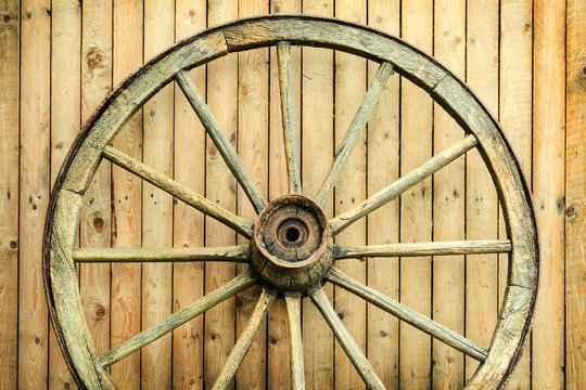 Vintage wagon wheel in front of a barn