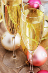 two glasses with champagne and Christmas tree decorations on the