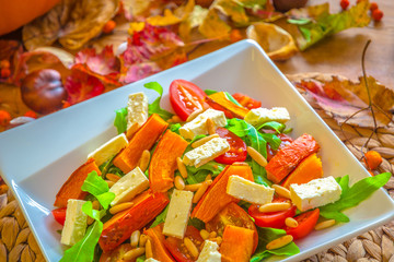 Salad of baked pumpkin,  feta cheese, roquette, pine nuts