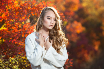 Fototapeta na wymiar Young woman with autumn leaves fall yellow garden background