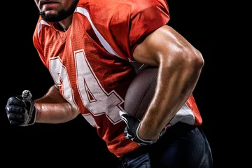 Foto op Plexiglas American football sportsman player on black background © 103tnn