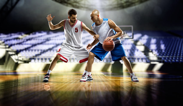 Two basketball players in action in the gym