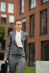 Business woman with briefcase walking in business district