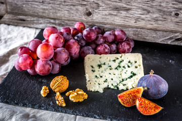 Blue cheese, figs, walnuts, blue raisins on black cliff
