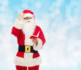 man in costume of santa claus with notepad