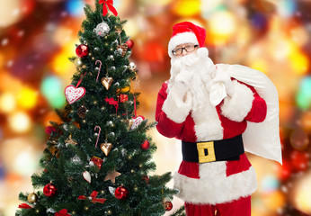 santa claus with bag and christmas tree
