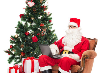 man in costume of santa claus with laptop
