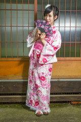 Asian woman in kimono holding fan