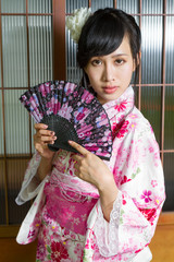 Asian woman in kimono holding fan