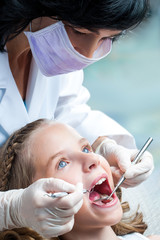 Obraz na płótnie Canvas Female Dentist working on kids teeth.