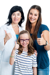 Teen girl and younger sister with dentist.