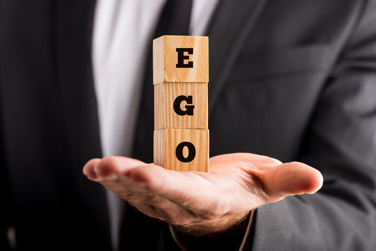 Businessman holding wooden alphabet blocks reading - Ego