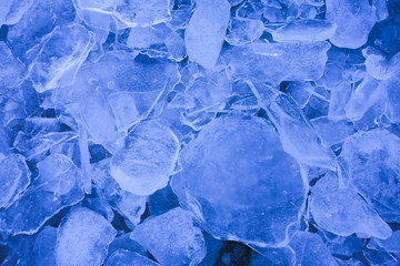 Shattered thin layers of blue ice sheets, background.