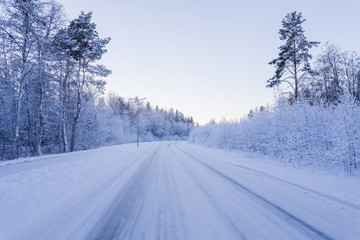 Fototapeta na wymiar Winter forest with road covered with snow
