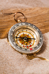 compass on beach sand