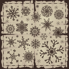 Set of different snowflakes over old damaged page.
