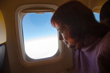 Traveling. Woman is sitting in the airplane.