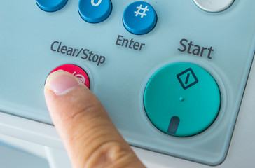 Office life, hand pressing stop button on fax, copy machine
