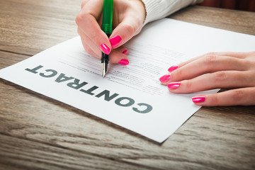 person's hand signing an important document