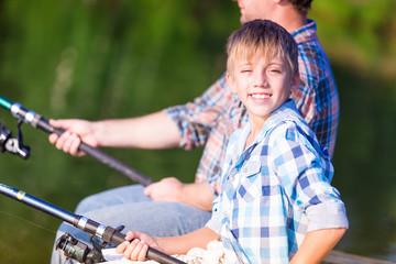 boy and his father fishing togethe