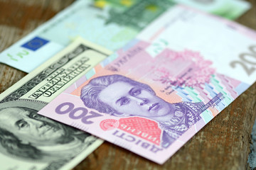 Obraz na płótnie Canvas dollars euro and hryvnia banknotes on wooden background