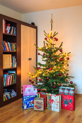 Decorated Christmas tree with gifts in room