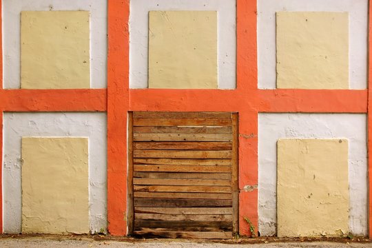 Old White Wall With Checkered Pattern Detail and wooden doorway