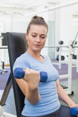 Fototapeta premium Fit brunette lifting blue dumbbells