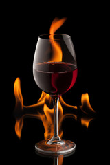 glass of wine on black background with fire splash