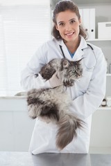 Smiling vet with a maine coon in her arms