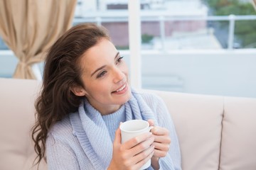 Pretty brunette having coffee on the couch