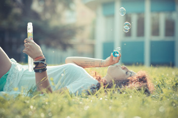 young beautiful moroccan curly woman blowing bubbles