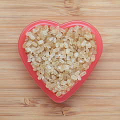Brown cane sugars in a heart bowl