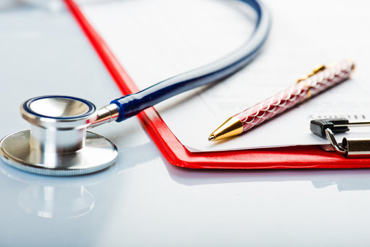 medical history with stethoscope and pen