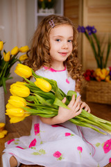Obraz na płótnie Canvas Beautiful girl with yellow tulips