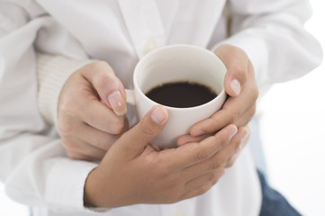 The hands of parents and children with hot coffee