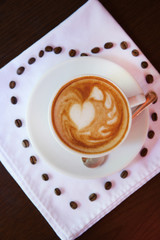 Cup of coffee with cute drawing in cafe